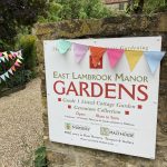sign showing details of East Lambrook Manor and its opening times with colourful bunting